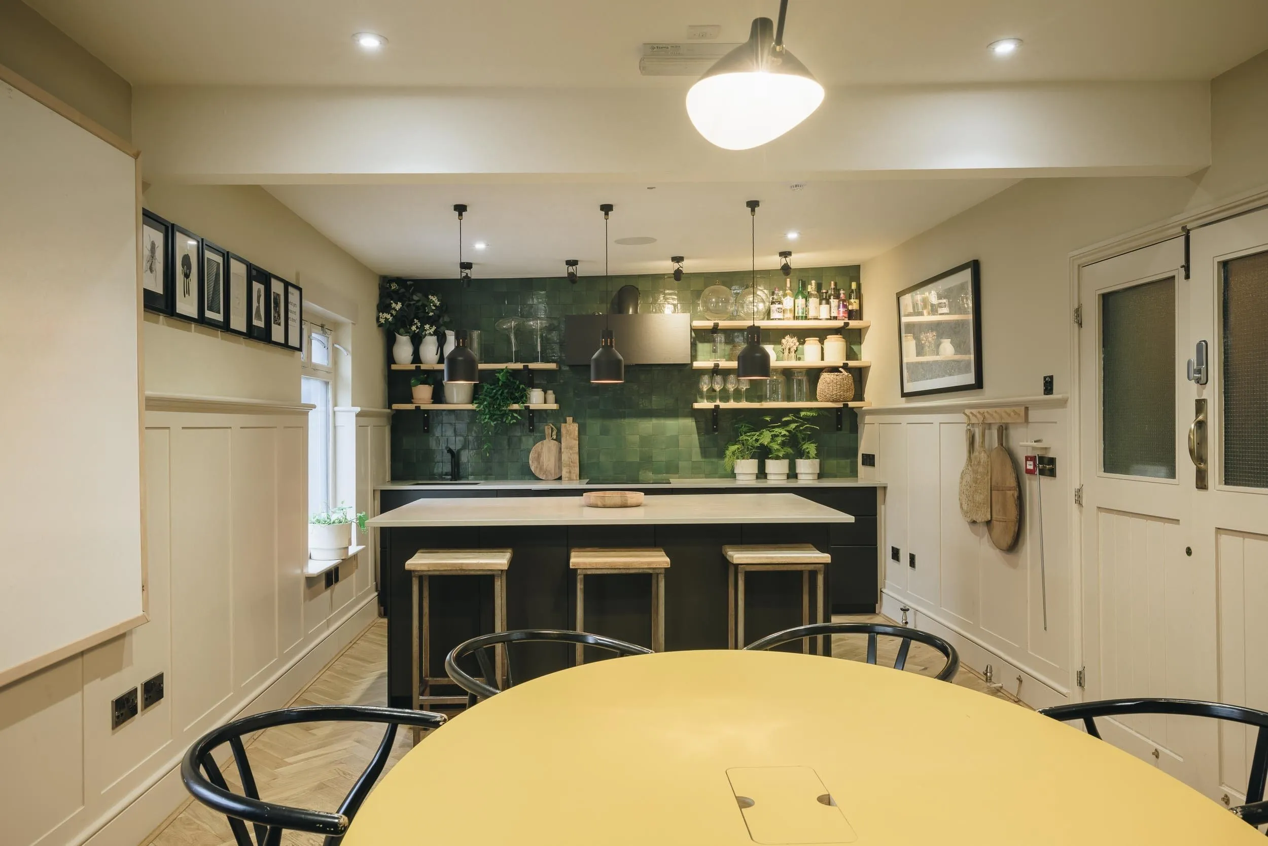 The Studio dining table in front of the kitchen